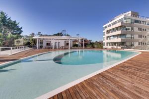 a swimming pool on a deck next to a building at Oceana Suites en Isabel, frente a playa Mansa in Punta del Este