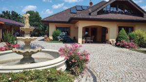 uma casa com uma fonte em frente a uma casa em Ubytování Carmen em Česká Skalice