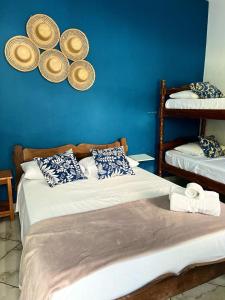a bedroom with two beds and a blue wall at Pousada Marques in Paraty