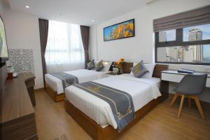 芽莊的住宿－Skylight Hotel Nha Trang，一间卧室设有两张床、一张桌子和一个窗口。