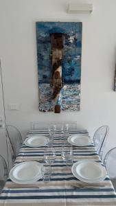 a table with glasses and a painting on the wall at Seafront rooftop flat w/ terrace in Portovenere