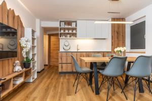 a kitchen and dining room with a wooden table and chairs at Hiša Rodica in Bohinj