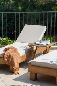 a bed and a table with a pair of glasses on it at Hôtel L'Escalet in Ramatuelle