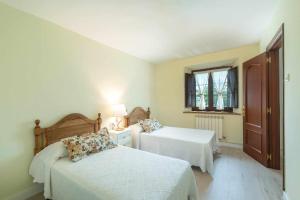 a bedroom with two beds and a window at Casa La venta de Pedro in Ribadesella