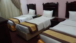 En eller flere senge i et værelse på فندق روابي العزيزية-Rawaby Hotels