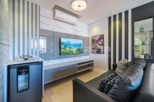 ein Wohnzimmer mit einem Sofa und einem TV in der Unterkunft SD 202 · Excelente Apartamento em condomínio com Rooftop e Piscina. in Bombinhas