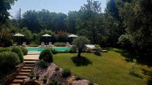 um quintal com uma piscina e um jardim em Aux Couleurs d'Esteil em Sainte-Nathalène