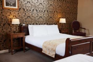 Habitación de hotel con 1 cama y 2 sillas en Kings Arms Hotel by Greene King Inns en Westerham