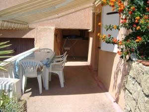 Un patio con mesa y sillas y flores. en Studio Olmeto, en Olmeto