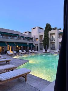 een groot zwembad met ligstoelen en een hotel bij Hotel Ambrosia in Bitez