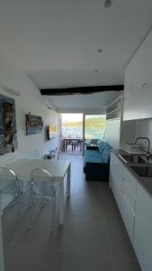 uma cozinha e sala de estar com mesa e cadeiras em Seafront rooftop flat w/ terrace em Portovenere