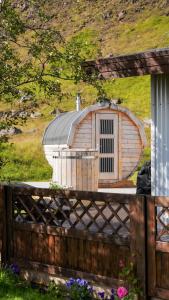 un pequeño cobertizo con techo sobre una valla en Kamburinn Cottage, en Hveragerði