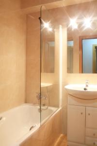 a bathroom with a shower tub and a sink at Vista Arinsal Apartments in Arinsal