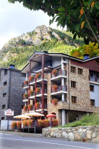 un edificio con ombrelloni di fronte a una montagna di Vista Arinsal Apartments ad Arinsal