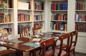 a dining room table with chairs and wine glasses at Kings Arms Hotel by Greene King Inns in Westerham