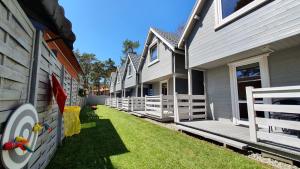 a row of houses with white fences on the grass at Domki Polarne in Dziwnówek