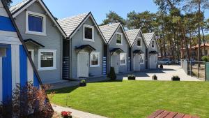 a row of houses with a lawn in front of them at Domki Polarne in Dziwnówek