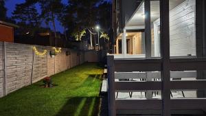 a backyard with a bench next to a house at night at Domki Polarne in Dziwnówek