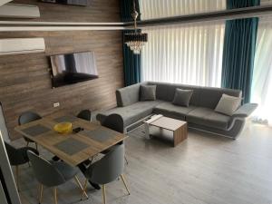 uma sala de estar com um sofá e uma mesa em Apartament Maya Lumina em Lumina