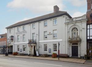 a white building on the side of a street at Kings Arms Hotel by Greene King Inns in Westerham
