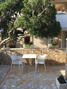 a white table and two chairs on a stone patio at Apartments Delic in Ražanac