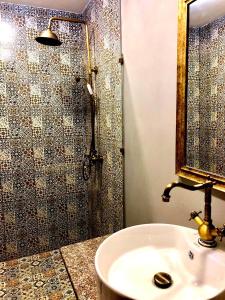 a bathroom with a sink and a shower with a mirror at Sahil Inn Baku Hotel Formula 1 View in Baku