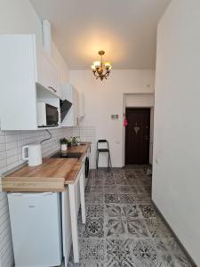 a kitchen with white cabinets and a tile floor at Студіо Личаківська 19 in Lviv +11 photos
