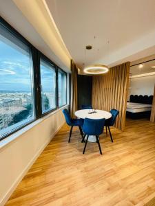 una sala da pranzo con tavolo, sedie e finestre di West View Studio a Cluj-Napoca Altre 4 foto