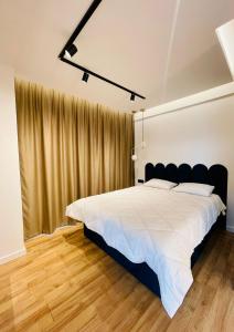 una camera da letto con un letto grande con testiera nera di West View Studio a Cluj-Napoca