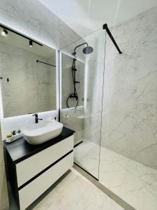 un bagno bianco con lavandino e doccia di West View Studio a Cluj-Napoca