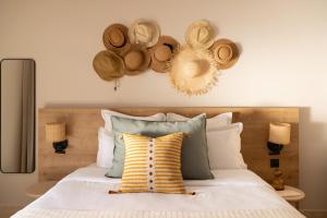 a bedroom with a bed with hats on the wall at Hôtel L'Escalet in Ramatuelle