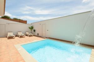 - une piscine avec une fontaine dans le patio dans l'établissement Villa con piscina junto a la playa, à La Estrella