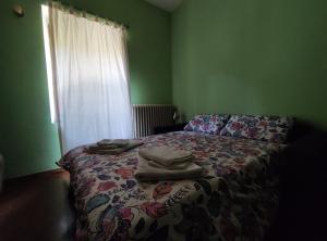 un letto in una stanza verde con sopra dei vestiti di B&B Da Dodo' a Calizzano