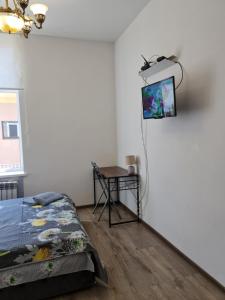 a bedroom with a bed and a tv on the wall at Студіо Личаківська 19 in Lviv
