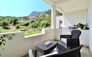 a balcony with chairs and a table with food on it at Apartmani Kljajevic Sutomore in Bar