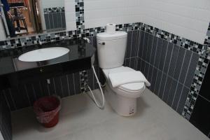 La salle de bains est pourvue de toilettes et d'un lavabo. dans l'établissement Triton Hotel Nakhonratchasima โรงแรมไททัน, à Nakhon Ratchasima