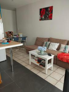 ein Wohnzimmer mit einem Sofa und einem Tisch in der Unterkunft Blanc de Tardy in Saint-Étienne