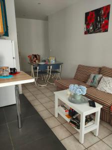 a living room with a couch and a table at Blanc de Tardy in Saint-Étienne