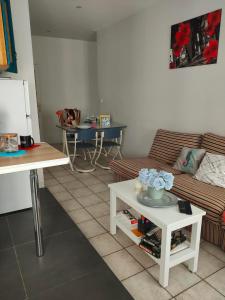 - un salon avec un canapé et une table dans l'établissement Blanc de Tardy, à Saint-Étienne