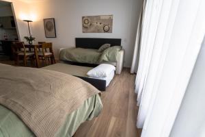 a bedroom with two beds and a table and chairs at Barrancas Quality Apartments in Buenos Aires