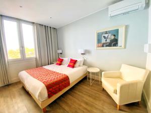 ein Schlafzimmer mit einem Bett und einem Stuhl in der Unterkunft Hotel Le Bon Port in Collioure