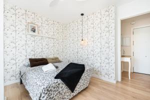 una camera con letto e parete con carta da parati di Apartamento La Ermita Comfort a Torrevieja