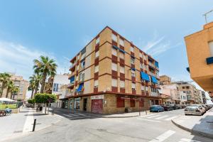 un palazzo alto in una strada di città con una strada di Apartamento La Ermita Comfort a Torrevieja