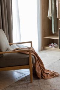 a room with a chair with a book on the floor at Hôtel L'Escalet in Ramatuelle
