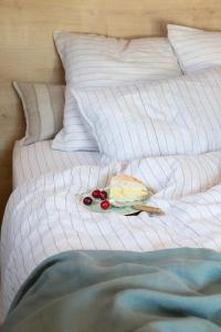 a white bed with a plate of cake and fruit on it at Hôtel L'Escalet in Ramatuelle