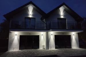 a house with two garage doors at night at Domki Kapitalne in Władysławowo