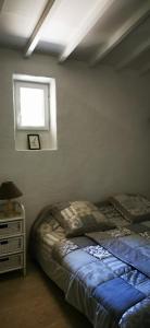 Schlafzimmer mit einem Bett und einem Fenster in der Unterkunft Maison provençale en pierres sèches in Gordes