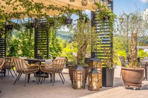 un patio esterno con sedie, tavoli e alberi di Srebrny Bucznik Wellness & Restaurant a Istebna