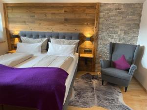 a bedroom with a large bed and a chair at Appartement Thunhart Wilfried&Elisabeth in Altenmarkt im Pongau