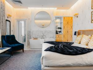 a bedroom with a bed and a tub and a mirror at The Spa Hotel in Royal Tunbridge Wells